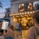 Zwei Menschen prüfen vor einem Kino das Programm auf einem Smartphone.
